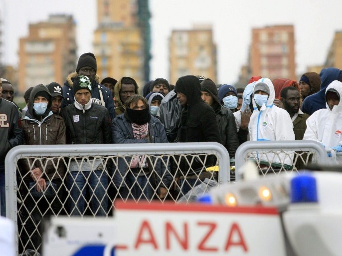 Migrants wait to disembark from a ship on February 17, 2015 in the port of Porto Empedocle, south Sicily, following a rescue operation of migrants as part of the International Frontex plan (Triton). The Italian coastguard launched a massive operation Sunday to rescue more than 2,000 migrants in difficulty between the Italian island of Lampedusa and the Libyan coast, local media said. The emergency rescue came on the same day Italy said it was evacuating staff from its embassy in Libya and suspending operations there, highlighting the worsening security situation in the violence-plagued country. AFP PHOTO / MARCELLO PATERNOSTRO