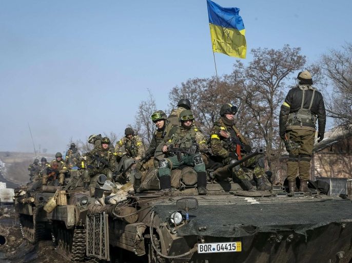 Members of the Ukrainian armed forces ride on armoured personnel carriers (APC) near Debaltseve, eastern Ukraine, February 12, 2015. Germany, France, Russia and Ukraine agreed a deal on Thursday that offers a "glimmer of hope" for an end to fighting in eastern Ukraine after marathon overnight talks. REUTERS/Gleb Garanich (UKRAINE - Tags: POLITICS CIVIL UNREST CONFLICT MILITARY)