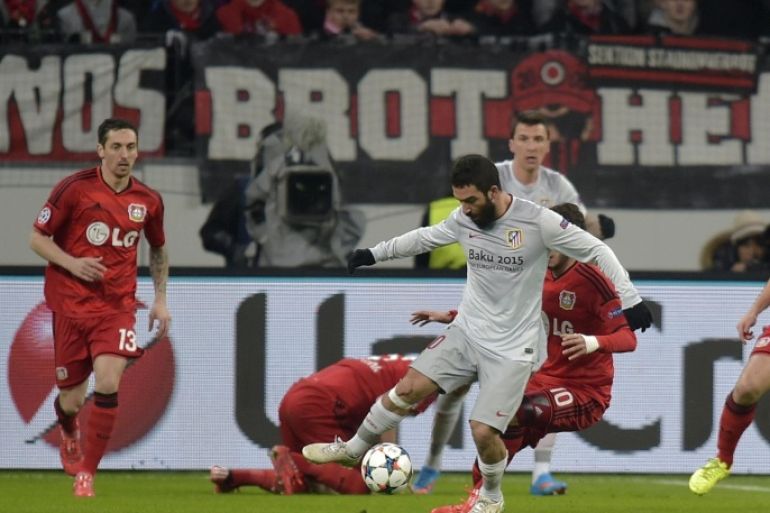 Atletico's Arda Turan, centre controls the ball during the Champions League round of 16 first leg soccer match between Bayer 04 Leverkusen and Atletico de Madrid on Wednesday, Feb. 25, 2015 in Leverkusen, Germany. (AP Photo/Martin Meissner)