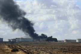 Black smoke billows out of a storage oil tank in the port of Es Sider in Ras Lanuf December 25, 2014. A rocket hit a storage tank at the eastern Libyan oil of port Es Sider as armed factions allied to competing governments fought for control of the country's biggest export terminal, officials said on Thursday. REUTERS/Stringer (LIBYA - Tags: CIVIL UNREST POLITICS TPX IMAGES OF THE DAY)