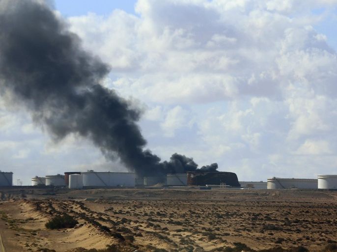 Black smoke billows out of a storage oil tank in the port of Es Sider in Ras Lanuf December 25, 2014. A rocket hit a storage tank at the eastern Libyan oil of port Es Sider as armed factions allied to competing governments fought for control of the country's biggest export terminal, officials said on Thursday. REUTERS/Stringer (LIBYA - Tags: CIVIL UNREST POLITICS TPX IMAGES OF THE DAY)