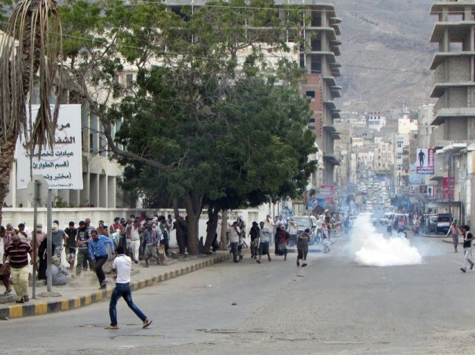 ADEN, YEMEN - FEBRUARY 15: Security forces intervene with tear gas as pro-separatist Yemenis stage a protest in Kraytar region of Aden, Yemen on February 15, 2015. Protestors hold flags, set tires fire during demonstration.