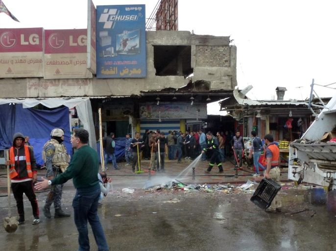 Iraqi's clean the street after a suicide bomber detonated explosives inside a restaurant in Baghdad al-Jadida, east of the capital, on February 7, 2015. Bombings in the Iraqi capital killed at least 17 people, hours before a years-old nightly curfew is due to be lifted, officials said. AFP PHOTO/SABAH ARAR