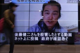 A pedestrian walks past television screens displaying a news program about Japanese journalist Kenji Goto, who was held hostage by Islamic State militants, on a street in Tokyo February 1, 2015. Islamic State militants said they had beheaded a second Japanese hostage, journalist Kenji Goto, prompting Abe to vow to step up humanitarian aid to the group's opponents in the Middle East and help bring his killers to justice. The words on the screen (top L) read, "Goto was murdered ?" REUTERS/Yuya Shino (JAPAN - Tags: POLITICS CIVIL UNREST)