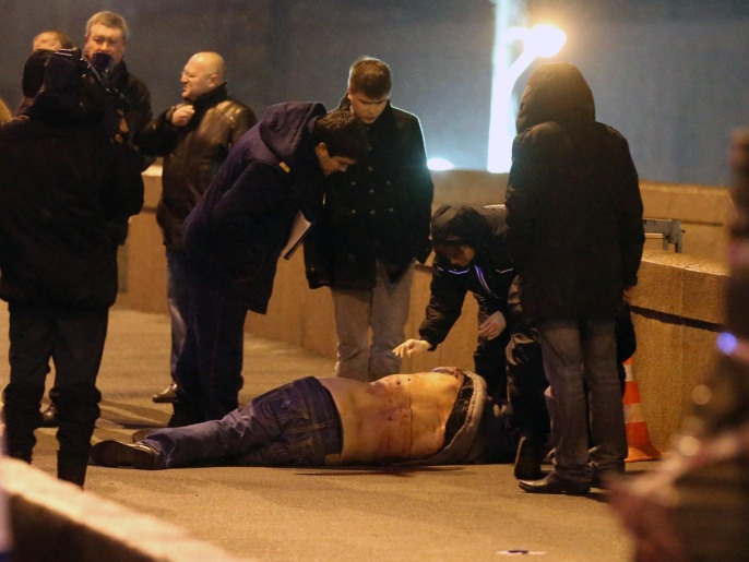 ‪‬  نيمتسوف وهو ملقى على الأرض يحيط به رجال الشرطة الروسية(غيتي)