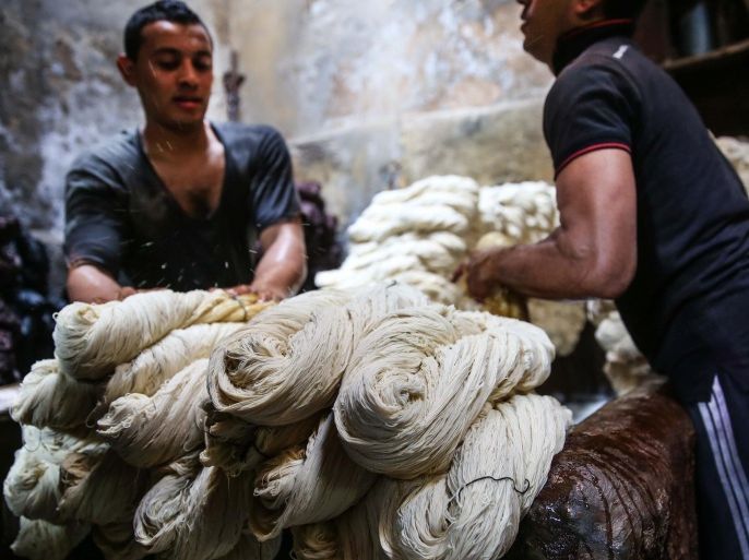 CAIRO, EGYPT - NOVEMBER 18: Natural Dyeing with Madder Root continues over many years at the atelier of craftsman Mahmood Sellame (not seen) in Al-Hussein district of Cairo, Egypt on November 18, 2014. Process starts with blending madder roots and hot water to obtain the color in a dye pot. Then, materials such as yarns, wool, silk or cotton are soaked in this dye pot. After that these materials are squeezed in a turning machine. Final step is that dyed materials are hanged for drying in open-air.