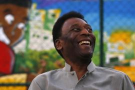 Brazilian soccer legend Pele laughs during the inauguration of a refurbished soccer field at the Mineira slum in Rio de Janeiro September 10, 2014. The soccer pitch was refurbished by Anglo-Dutch oil company Royal Dutch Shell using underground tiles which capture kinetic energy created by the movement of the players and combined it with the solar energy that feeds its new floodlights, the organizers said. REUTERS/Ricardo Moraes (BRAZIL - Tags: ENERGY SPORT SOCCER SOCIETY BUSINESS)