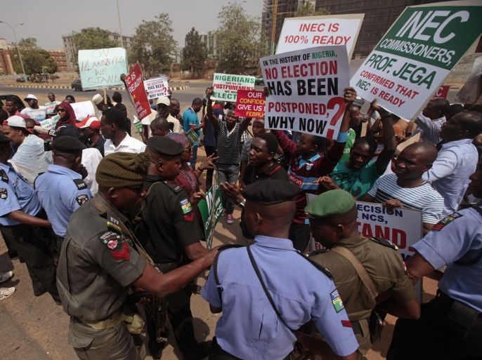 Protestors hold banners during a protest in Abuja, Nigeria, Saturday, Feb. 7, 2015, against the possible postponement of the Nigerian elections. Civil rights groups staged a small protest Saturday against any proposed postponement. (AP Photo/Lekan Oyekanmi)