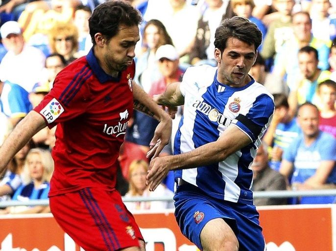 Espanyol's Victor Sanchez (R) in action against Osasuna's Lolo (L) during the Spanish Primera Division soccer match between RCD Espanyol and CA Osasuna at Cornella-El Prat stadium in Barcelona, northeastern Spain, 11 May 2014.