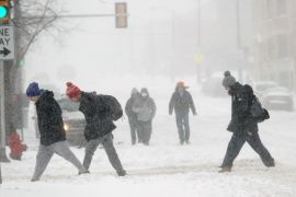 Students fight the snow and wind while crossing the street near the Marquette University campus, Sunday, Feb. 1, 2015, in Milwaukee. A slow-moving winter storm blanketed a large swath of the Plains and Midwest in snow Sunday, forcing the cancellation of more than 1,500 flights and making roads treacherous. (AP Photo/Milwaukee Journal-Sentinel, Michael Sears)