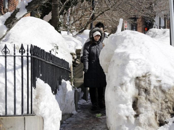 Pedestrians walk single file through snow banks on a Beacon Street sidewalk in Boston, Friday, Feb. 20, 2015. Midway through an epic winter that's shattered records and buried Boston in more than 8 feet of snow, locals and outsiders alike could be forgiven for wondering why a world-class city that's accustomed to heavy snowfall — and prides itself on being a global center of technology and innovation — can't seem to dig out and move on. (AP Photo/Elise Amendola)