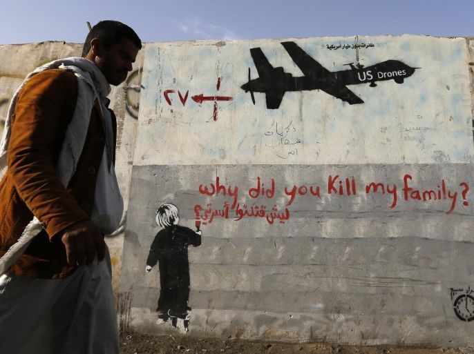 A man walks past a graffiti, denouncing strikes by U.S. drones in Yemen, painted on a wall in Sanaa November 13, 2014. Yemeni authorities have paid out tens of thousands of dollars to victims of drone strikes using U.S.-supplied funds, a source close to Yemen's presidency said, echoing accounts by legal sources and a family that lost two members in a 2012 raid. REUTERS/Khaled Abdullah (YEMEN - Tags: CIVIL UNREST MILITARY POLITICS SOCIETY)