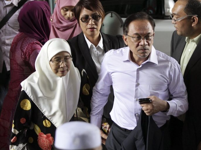 Malaysia's opposition leader Anwar Ibrahim (2nd R) arrives with his wife Wan Azizah (L), for the verdict in his final appeal against a conviction for sodomy, at the federal court in Putrajaya, February 10, 2015. Malaysia's highest court rejected on Tuesday Anwar's appeal against a 2014 sodomy conviction and upheld a five-year prison term that will likely end a political career marked by controversy. REUTERS/Stringer (MALAYSIA - Tags: POLITICS CRIME LAW TPX IMAGES OF THE DAY) NO SALES. NO ARCHIVES. FOR EDITORIAL USE ONLY. NOT FOR SALE FOR MARKETING OR ADVERTISING CAMPAIGNS