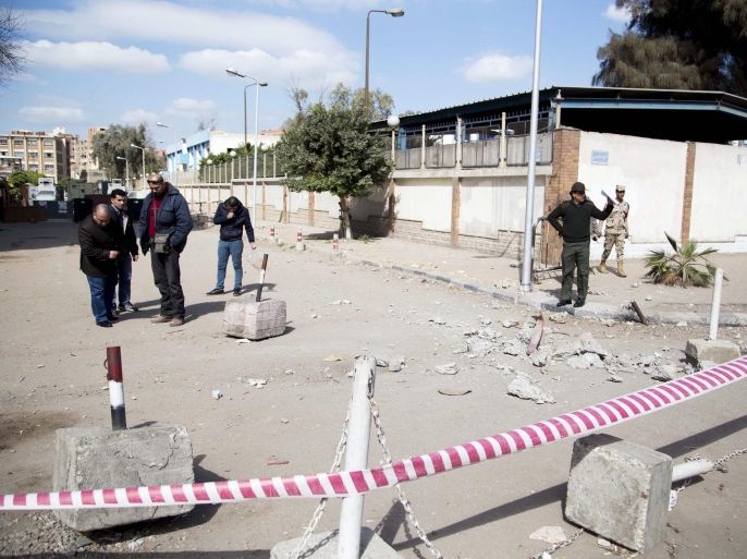 Members of the Egyptian security services inspect the site of a bomb blast in front of a police station in the Ain Shams are of Cairo, Egypt, 13 February 2015. Attacks on security forces have become common in Egypt, which is currently battling an insurgency in the north of Sinai, where two recent attacks left tens of soldiers dead.