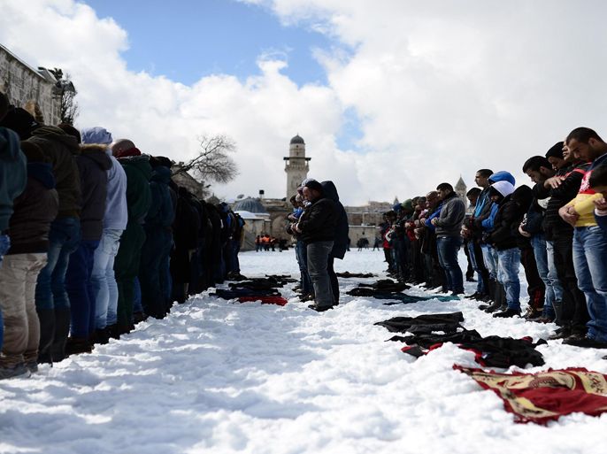 JERUSALEM - FEBRUARY 20: Palestinians perform Friday prayers at snow covered yard of Al Aqsa Mosque for Friday prayer after snowfall hit region on February 20, 2015.