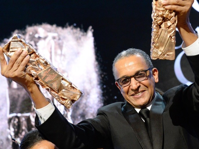 Mauritanian director Abderrahmane Sissako raises his trophies on stage after winning the Best Feature Film award for 'Timbuktu' during the 40th edition of the Cesar Awards ceremony on February 20, 2015 at the Chatelet theatre in Paris. AFP PHOTO / BERTRAND GUAY