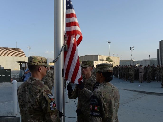 US soldiers wrap a half-mast US flag during a memorial ceremony in remembrance of those who perished thirteen years ago during the 9/11 attacks in the US, at a military base in Bagram, 50 kms north of Kabul on September 11, 2014. Ceremonies were held in tribute to the victims of the 9/11 attacks at bases across Afghanistan where troops are stuck in a seemingly un-winnable war against a Taliban guerrilla movement few Americans understand. AFP PHOTO/SHAH Marai