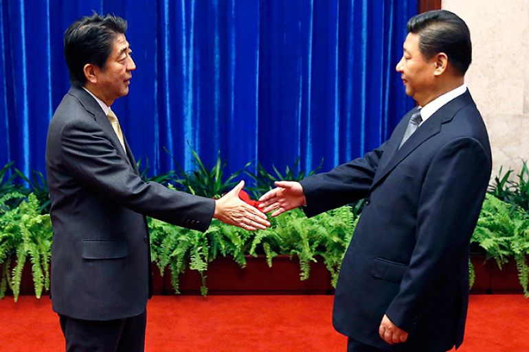 epaselect epa04483561 Japan's Prime Minister Shinzo Abe (L) shakes hands with China's President Xi Jinping (R) during their meeting at the Great Hall of the People, on the sidelines of the Asia Pacific Economic Cooperation (APEC) meetings, in Beijing, China, 10 November 2014. The APEC 2014 Summit and related meetings is being held in Beijing from 05 to 11 November, gathering leaders of 21 member economies. EPA/KIM KYUNG-HOON/POOL