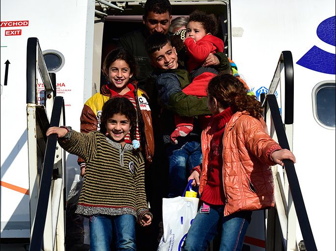 epa04657891 A Syrian refugee family disembarks from a plane on the airport Hannover-Langenhagen, in Langenhagen, Germany, 11 March 2015. A group of 179 Syrian refugees landed on the airport in the afternoon as part of the humanitarian admission of refugees. EPA/ALEXANDER KOERNER