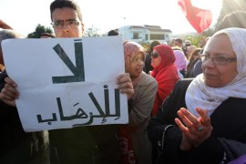A man holds a placard which reads 'no to terrorism' as he takes part in a protest outside the National Bardo Museum in Tunis, Tunisia on 19 March 2015. Tunisian authorities on 19 March 2015 announced arrests and stepped up security measures a day after a deadly attack on the capital's Bardo museum. Twenty-three people were killed on 18 March 2015 when two gunmen opened fire outside the popular tourist site before taking hostages inside the building.