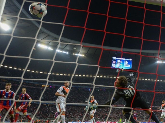 Shakhtar Donetsk's goalkeeper Andriy Pyatov looks after the ball as Bayern Munich's defender Holger Badstuber (2nd L) scores the 5-0 during the UEFA Champions League second-leg round of 16 football match FC Bayern Munich vs Shaktar Donetsk in Munich, southern Germany, on March 11, 2015. AFP PHOTO / ODD ANDERSEN