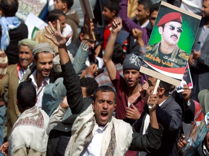 A Yemeni protester holds a portrait of Ahmed Ali Abdullah Saleh, the son of Yemen's former president Ali Abdullah Saleh who stepped down in early 2012, during a demonstration demanding him to rule the country, on March 10, 2015 in the capital Sanaa. AFP PHOTO / MOHAMMED HUWAIS
