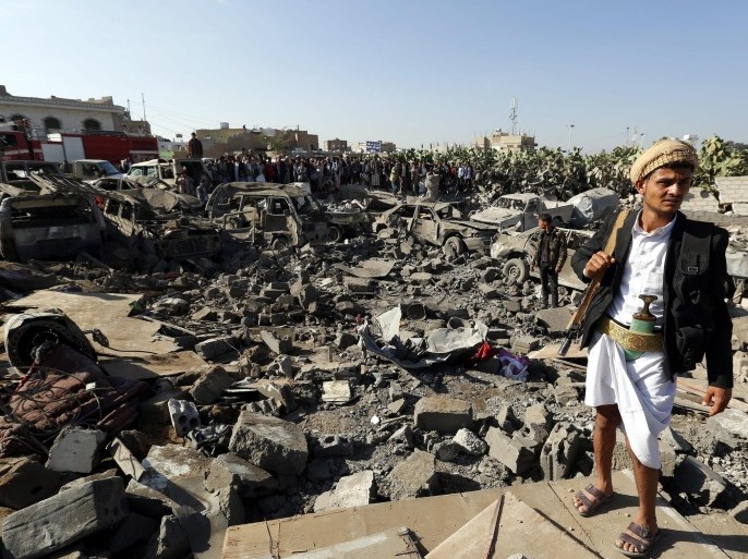 An armed member of Houthi militia (R) keeps watch as people gather beside vehicles which were allegedly destroyed by a Saudi air strike, in Sana'a, Yemen 26 March 2015. Saudi Arabia and other Gulf states launched air strikes against Houthi rebels which have taken over large parts of Yemen, attacking the Sana'a military Airport and Jiraf area, a Houthi stronghold. The strikes were 'in support of the people of Yemen and their legitimate government,' Saudi Arabia's Washington ambassador Adel al-Jubeir said. The military operation by a 'coalition of over 10 countries' was in response to an appeal from embattled Yemeni President Abdo Rabbo Mansour Hadi, al-Jubeir said.