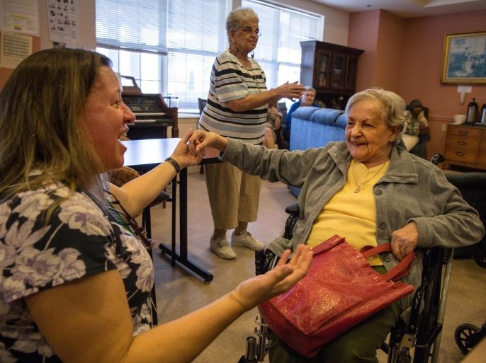 MANASSAS, VA - NOV21: Consuela Rivera, 88, dances in her wheelchair with activity aide Tina Burhans-Robinson, during karaoke at Birmingham Green, an elder care residence in Manassas, VA, November 21, 2014. With the U.S. population aging and Alzheimer's more widespread, science is looking for ways to slow or delay the onset of dementia in aging Americans. Among the approaches is trying to determine whether art, music and dance or movement can also alleviate the problems attendant with dementia. The federal government is funding a study at Birmingham Green with George Mason University to see whether there is a scientific basis to believe that art is actually medically beneficial.