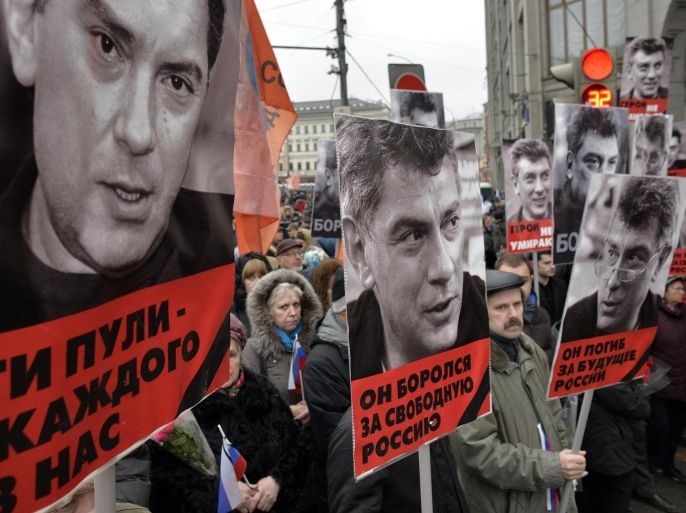 Russia's opposition supporters carry portraits of Kremlin critic Boris Nemtsov during a march in central Moscow on March 1, 2015. Words under portraits read ''Those bullets for everyone of us', 'He fought for a free Russia', 'He died for the future of Russia'. The 55-year-old former first deputy prime minister under Boris Yeltsin was shot in the back several times just before midnight on February 27 as he walked across a bridge a stone's throw from the Kremlin walls. AFP PHOTO / YURI KADOBNOV