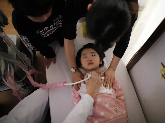 RNPS - REUTERS NEWS PICTURE SERVICE - PICTURES OF THE YEAR 2014A doctor conducts a thyroid examination on a five-year-old girl as her older brother and a nurse take care of her at a clinic in a temporary housing complex in Nihonmatsu, west of the tsunami-crippled Fukushima Daiichi nuclear power plant, Fukushima prefecture, in this February 27, 2014 file photo. REUTERS/Toru Hanai/Files (JAPAN - Tags: DISASTER EDUCATION ENVIRONMENT HEALTH TPX IMAGES OF THE DAY)