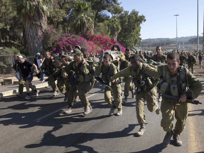 Israeli soldiers from the Golani Brigade take part in a 70-kilometre (43-mile) march in northern Israel, marking the completion of their advanced training, at the end of which they receive their brown beret October 7, 2014. Soldiers from each platoon carried two of their comrades on a stretcher for the last three kilometres (1.9 miles) as part of the march. REUTERS/Baz Ratner (ISRAEL - Tags: MILITARY)