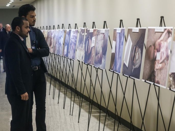 NEW YORK, NY - MARCH 12: Visitors look at the images of dead bodies at the UN headquarters in New York on March 12, 2015. Images of torture carried out by the Syrian regime forces are on display in the halls of the UN.