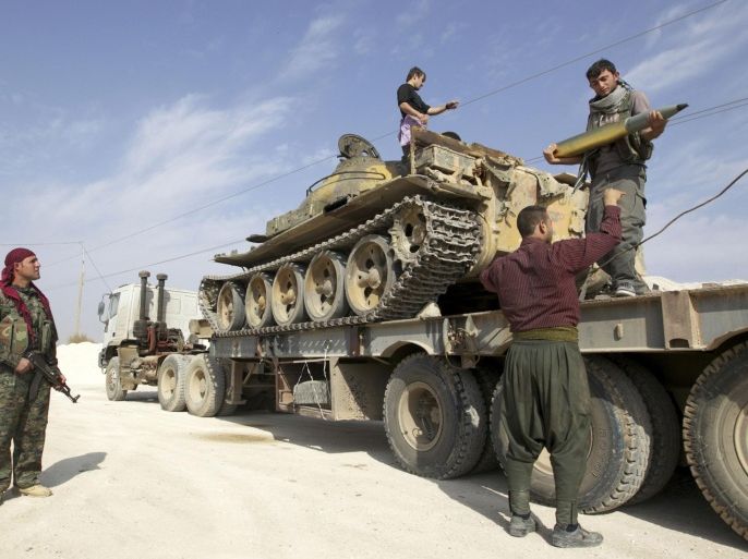 Members of Kurdish People's Protection Units (YPG) are seen on a military truck that belonged to the Islamist rebels after capturing it near Ras al-Ain, in the province of Hasakah November 6, 2013. Redur Xelil, spokesman for the armed wing of the Syrian Kurdish Democratic Union Party (PYD), said Kurdish militias had seized the city of Ras al-Ain and all its surrounding villages. Syrian Kurdish fighters have captured more territory from Islamist rebels in northeastern Syria, a Kurdish militant group said on Monday, tightening their grip on an area where they have been setting up autonomous rule. REUTERS/Stringer (SYRIA - Tags: POLITICS CIVIL UNREST)