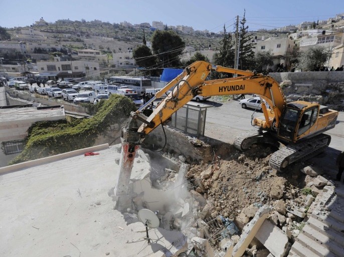 A bulldozer demolishes a house in Jabel Mukaber, a Palestinian village in the suburbs of East Jerusalem February 5, 2014. Three Palestinians were detained on Wednesday for throwing stones at Israeli policemen who were securing a court-ordered demolition of some three houses in East Jerusalem suburbs, a police spokesman said. REUTERS/Ammar Awad (JERUSALEM - Tags: POLITICS CIVIL UNREST)