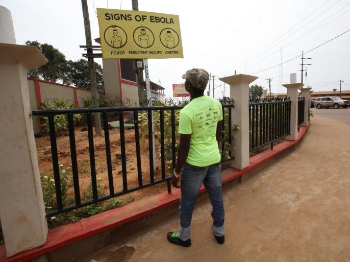 A Liberia man reads an ebola awareness billboard in Paynesville City, Liberia. 29 March 2015. A Liberian woman who became the country's first Ebola patient in more than a month has died. Officials say two more people are suspected of having the virus, halting the country's plans to be Ebola-free by April.
