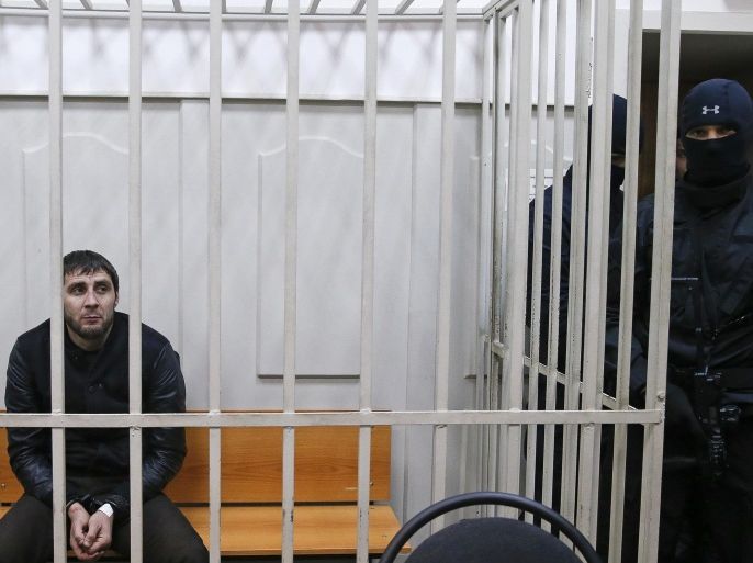 Zaur Dadayev (L), charged with involvement in the murder of Russian opposition figure Boris Nemtsov, looks out from inside a defendants' cage in a court building in Moscow, March 8, 2015. Russian authorities said on Sunday they were holding five men over the killing of Kremlin critic Boris Nemtsov, one of whom served in a police unit in the Russian region of Chechnya, according to a law enforcement official. A judge ruled that all five should be held in custody and said that one of them, Zaur Dadayev, had admitted his involvement in the killing when questioned by investigators. REUTERS/Tatyana Makeyeva (RUSSIA - Tags: CRIME LAW POLITICS)