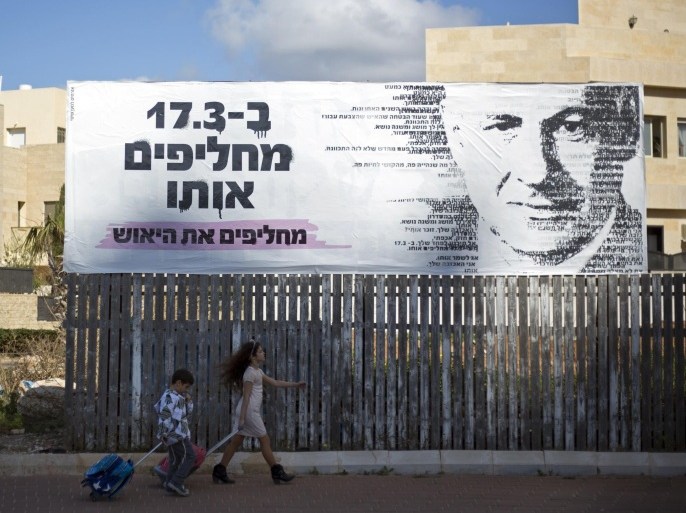 Children pass by an election campaign banner with a painting of Israel's Prime Minister Benjamin Netanyahu, in Netanya, Israel, Monday, March 2, 2015. Israel will hold a general election on March 17 and Netanyahu seeks to secure his fourth term as prime minister. Poster in Hebrew reads, "On March 17, we replace him, we replace the despair." (AP Photo/Ariel Schalit)