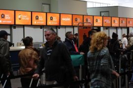 Passengers queue to drop their bags at EasyJet Plc check-in desks inside the north terminal of London Gatwick airport in Crawley, U.K., on Thursday, Nov. 6, 2014. EasyJet has established a footprint at locations such as Amsterdam Schiphol, where it announced plans to base planes in July, and is ramping up operations at London Gatwick airport, its biggest single base.