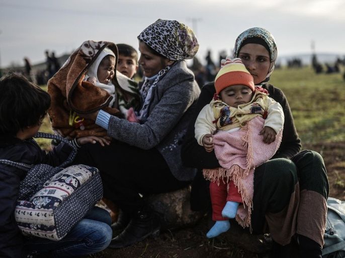 Syrian Kurdish women sit with their children near the Turkish-Syrian border at Suruc, in Sanliurfa province on January 27, 2015. Kurdish fighters have expelled Islamic State group militants from the Syrian border town of Kobane, a monitor and spokesman said today, dealing a key symbolic blow to the jihadists' ambitions. AFP PHOTO/BULENT KILIC