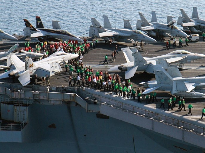 In this photo taken Friday, Oct. 10, 2014, U.S. sailors conduct a drill on the aircraft carrier USS George H.W. Bush in the Persian Gulf. On Thursday, Oct. 16, the U.S. conducted 14 airstrikes, hitting buildings controlled by the Islamic State group, sniping positions and a heavy machine gun, according to a statement issued by the U.S. military's central command. Over the last two weeks, U.S airstrikes in support of Kurdish fighters in the embattled border town of Kobani have killed hundreds of Islamic State fighters in Syria and Iraq, said Rear Adm. John Kirby. (AP Photo/Brian Stephen, U.S. Navy)