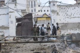 Somali security officers stand guard at the scene of a car bomb explosion in front of a hotel in Mogadishu, Somalia, 27 March 2015. Reports say that a car bomb explosion followed by gunfire at a popular hotel in Mogadishu killed at least several people on 27 March. No one has claimed responsibility though scuh attacks in Mogadishu are often carried out by Islamist militant group al-Shabab.