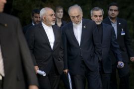 Iranian Foreign Minister Javad Zarif, left, talks with the head of the Iranian Atomic Energy Organization Ali Akbar Salehi, center, while walking after an afternoon meeting with U.S. Secretary of State John Kerry and U.S. officials at the Beau Rivage Palace Hotel in Lausanne, Switzerland, Friday, March 27, 2015. Iran's foreign minister is condemning Saudi-led airstrikes in Yemen but says the nuclear talks in Switzerland between his nation and six world powers remain focused on reaching a deal. (AP Photo/Brendan Smialowski, Pool)