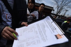 A family member of a Chinese passenger from the missing Malaysia Airlines flight MH370, shows off a signed petition to urge for the continuation of the search of the plane, after a prayer session at the Yonghegong Lama temple in Beijing on March 8, 2015. A year on, there remains no evidence to indicate what caused Malaysia Airlines Flight MH370 to vanish or where it ended up, despite the most expensive search operation in history. AFP PHOTO / GOH CHAI HIN