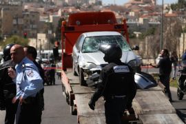 JERUSALEM - MARCH 06: Destroyed car used in attack is embarked to a truck at the site where several Israelis were injured on Friday after a yet-unidentified suspect drove a vehicle into a crowd of Israelis at Shimon HaTzadik trolley station in East Jerusalem, on March 06, 2015.