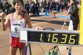Yusuke Suzuki of Japan poses next to his record after breaking the 20-kilometer race walk world record Sunday, March 15, 2015, during the IAAF Race Walking Challenge, in Nomi, central Japan. Suzuki won the race in his home town with a time of 1 hour, 16 minutes, 36 seconds, a mark 26 seconds faster than that set by Yohann Diniz of France just a week ago. (AP Photo/Kyodo News) JAPAN OUT, MANDATORY CREDIT