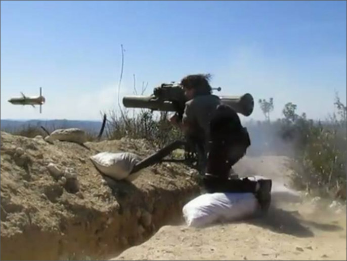 ‪(الجزيرة/أرشيف)‬ ِِأحد مسلحي المعارضة يطلق صاروخا على دبابة للنظام بمعارك اللاذقية