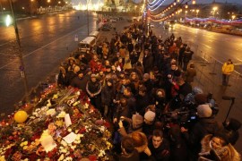 People gather at the site where Boris Nemtsov was recently murdered, with St. Basil's Cathedral and the Kremlin walls seen in the background, in central Moscow, February 28, 2015. The murder of Nemtsov drew condemnation on Saturday from leaders and politicians around the world, who paid tribute to the outspoken critic of President Vladimir Putin and Russia's role in the Ukraine crisis. REUTERS/Maxim Zmeyev (RUSSIA - Tags: POLITICS CRIME LAW CITYSCAPE)