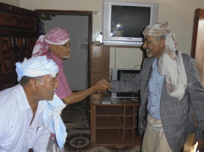 Yemen's Defence Minister General Mahmoud al-Subaihi (R) shakes hands with visitors in his home in al-Subaiha area of Yemen's southern province of Lahej, to which he arrived from the capital Sanaa March 8, 2015. Subaihi has fled Houthi-controlled Sanaa for Aden, officials said on Sunday, in a move expected to bolster President Abd-Rabbu Mansour Hadi in his power struggle with the Shi'ite Muslim group. Yemen is caught in a stand-off between the Western-backed president and the Iran-backed Houthi clan, now the country's de facto rulers. The group seized the presidential palace in Sanaa in January and confined the president to his private residence. Hadi managed to escape from the Houthis two weeks ago. REUTERS/Stringer (YEMEN - Tags: CIVIL UNREST POLITICS MILITARY)