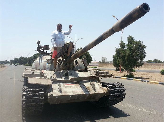 مواطن على متن دبابة للجان الشعبية التابعة للجيش اليمني بمدينة عدن (الجزيرة)