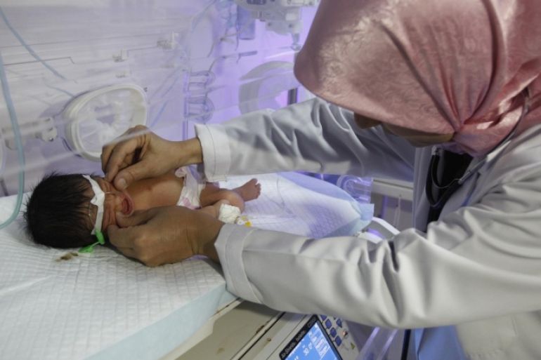 Pediatrician Samira al-Alani examines a child with a cleft lip in an incubator in a Falluja hospital, 50 km (31 miles) west of Baghdad, August 26, 2013. Alarmed by a rise in congenital anomalies in her city of Falluja, al-Aani launched a petition calling on the World Health Organisation (WHO) to release what she says are data collected more than a year ago on birth defects rates caused by the US-led 2003 war on Iraq for independent analysis. Picture taken August 26, 2013. REUTERS/Saad Shalash (IRAQ - Tags - Tags: HEALTH CONFLICT)
